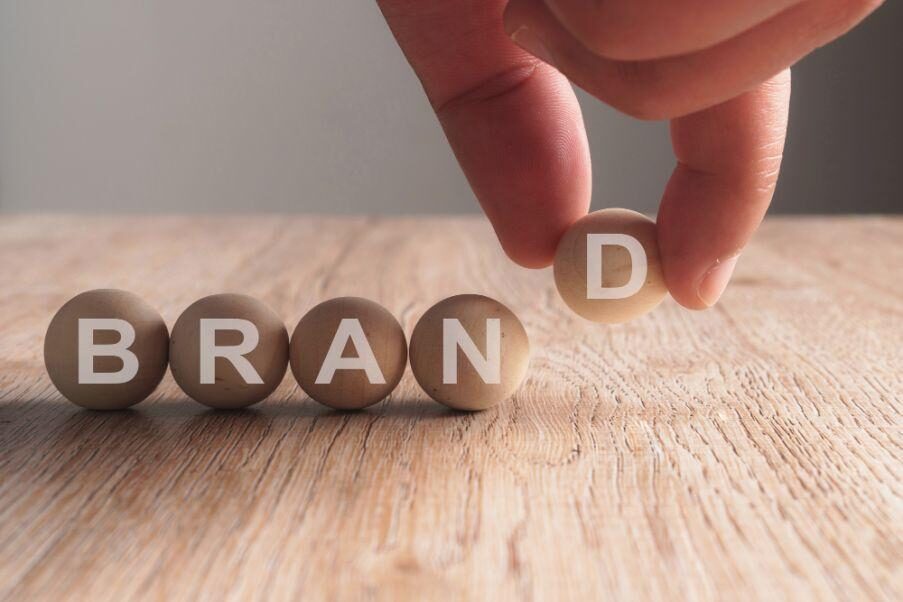 hand-putting-brand-word-written-wooden-ball